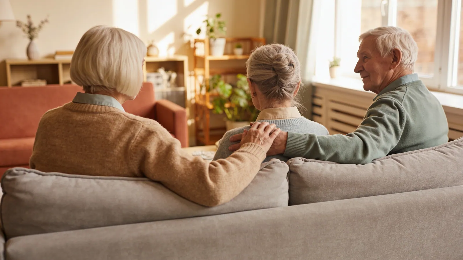 Three generations sitting together during a family visit in a care home lounge
